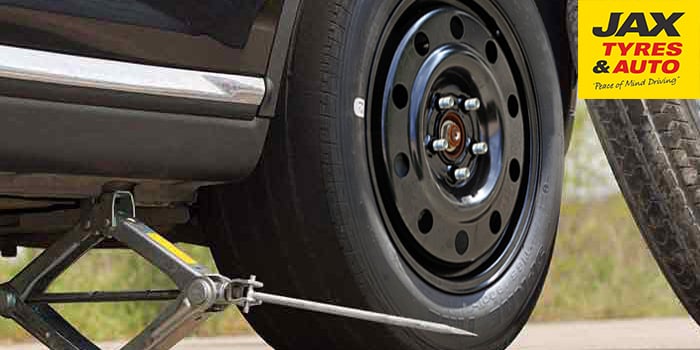 Changing car tyres: place the spare tyre into position