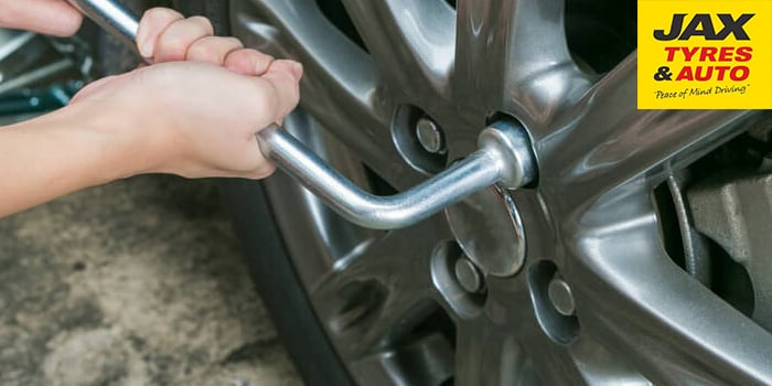 Changing a car tyre - lower the car off the jack and tighten the bolts